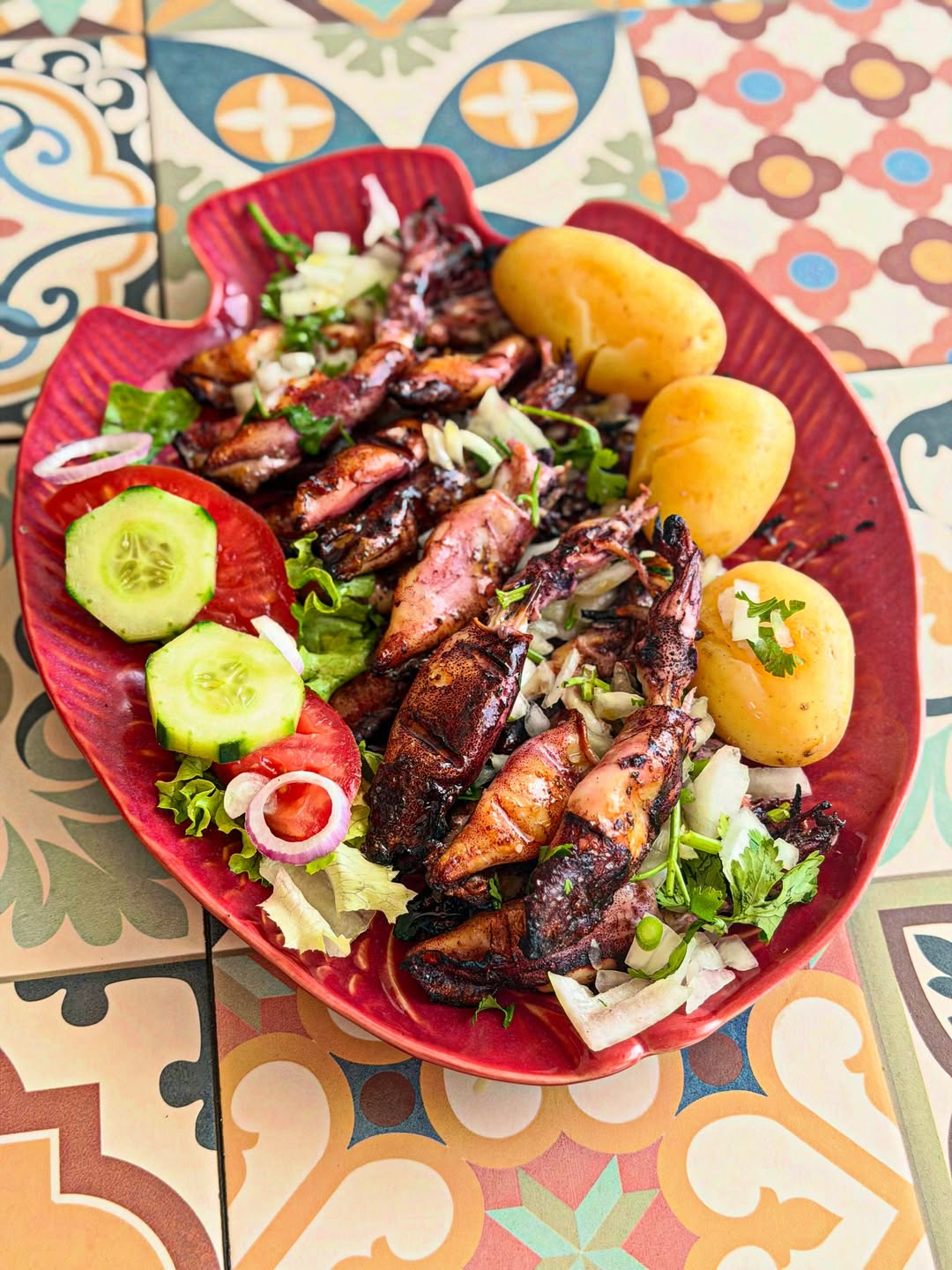 Carne grelhada com cebola e pimento, servida em prato vermelho